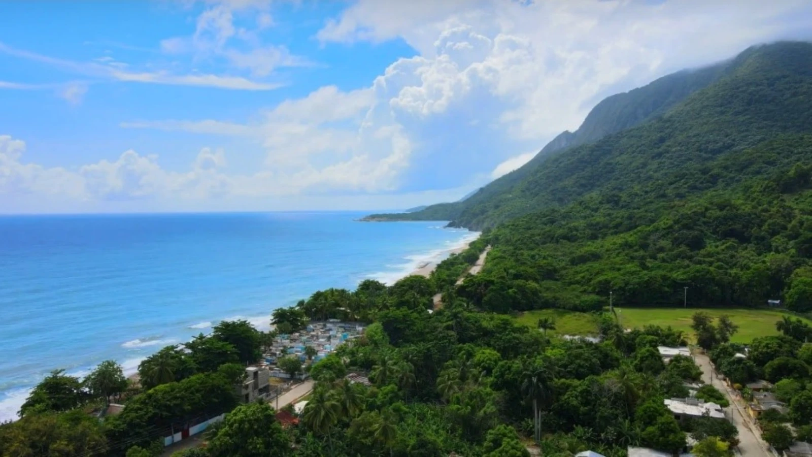Vista aérea de la costa de Barahona en La Ciénaga, con la sierra verde junto al mar Caribe