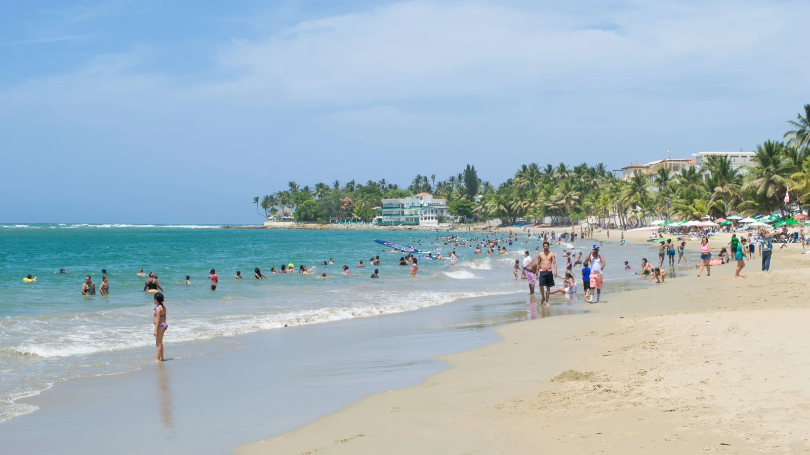 Playa de Cabarete con bañistas y palmeras