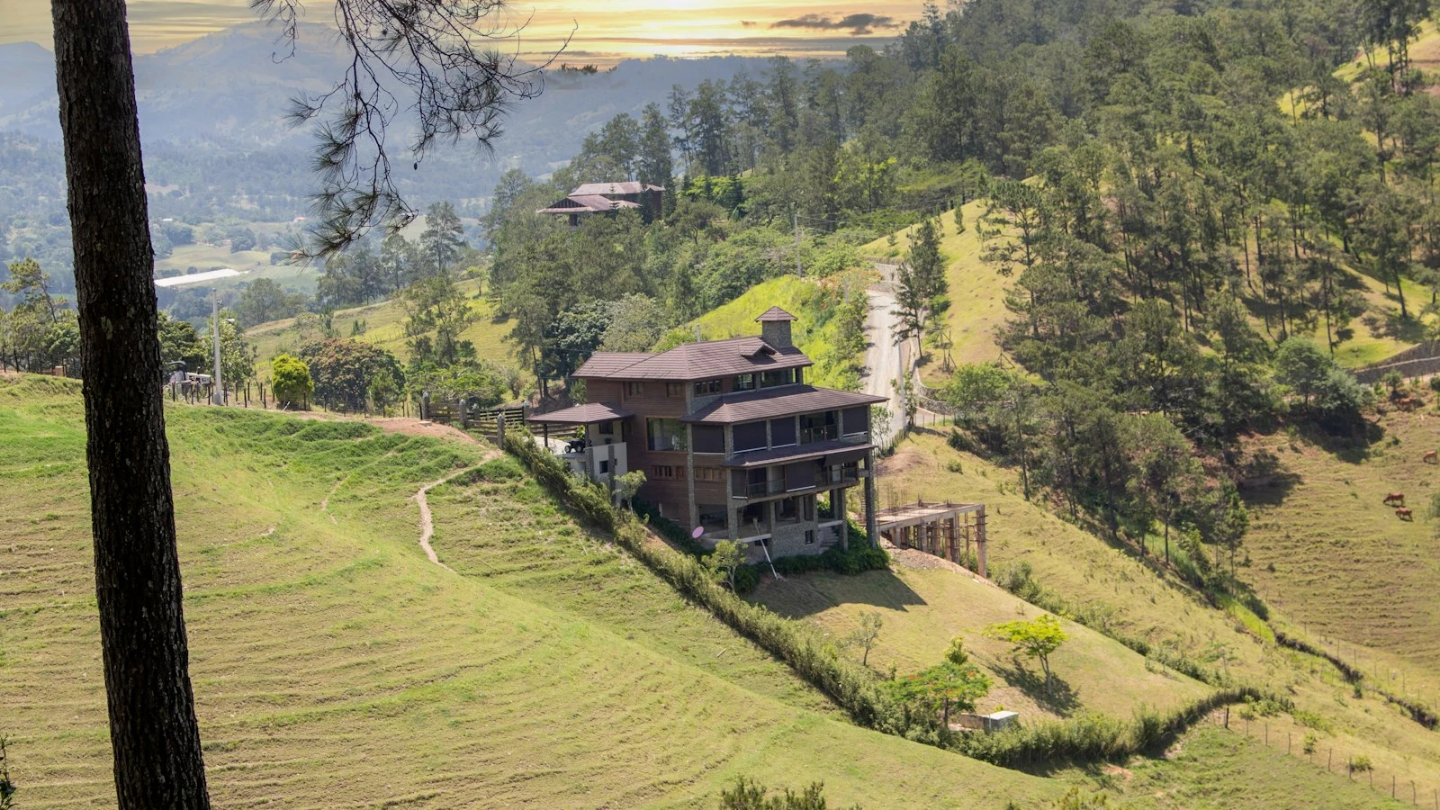 Casa de campo en una loma verde junto a una carretera rural en Jarabacoa, en el Cibao