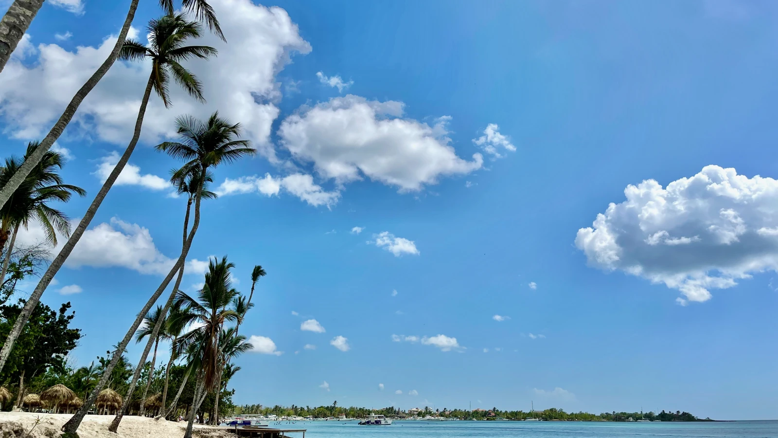 Playa de Bayahibe en La Altagracia: arena blanca, agua turquesa, palmeras y un bote