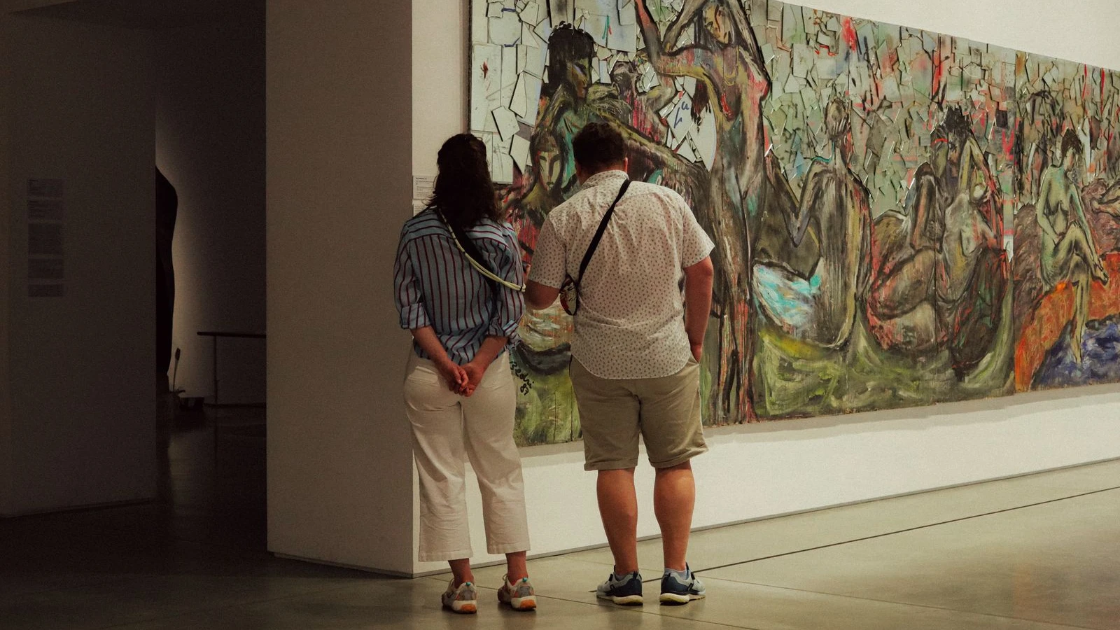 Dos visitantes de espaldas mirando un cuadro abstracto grande en una sala blanca de museo