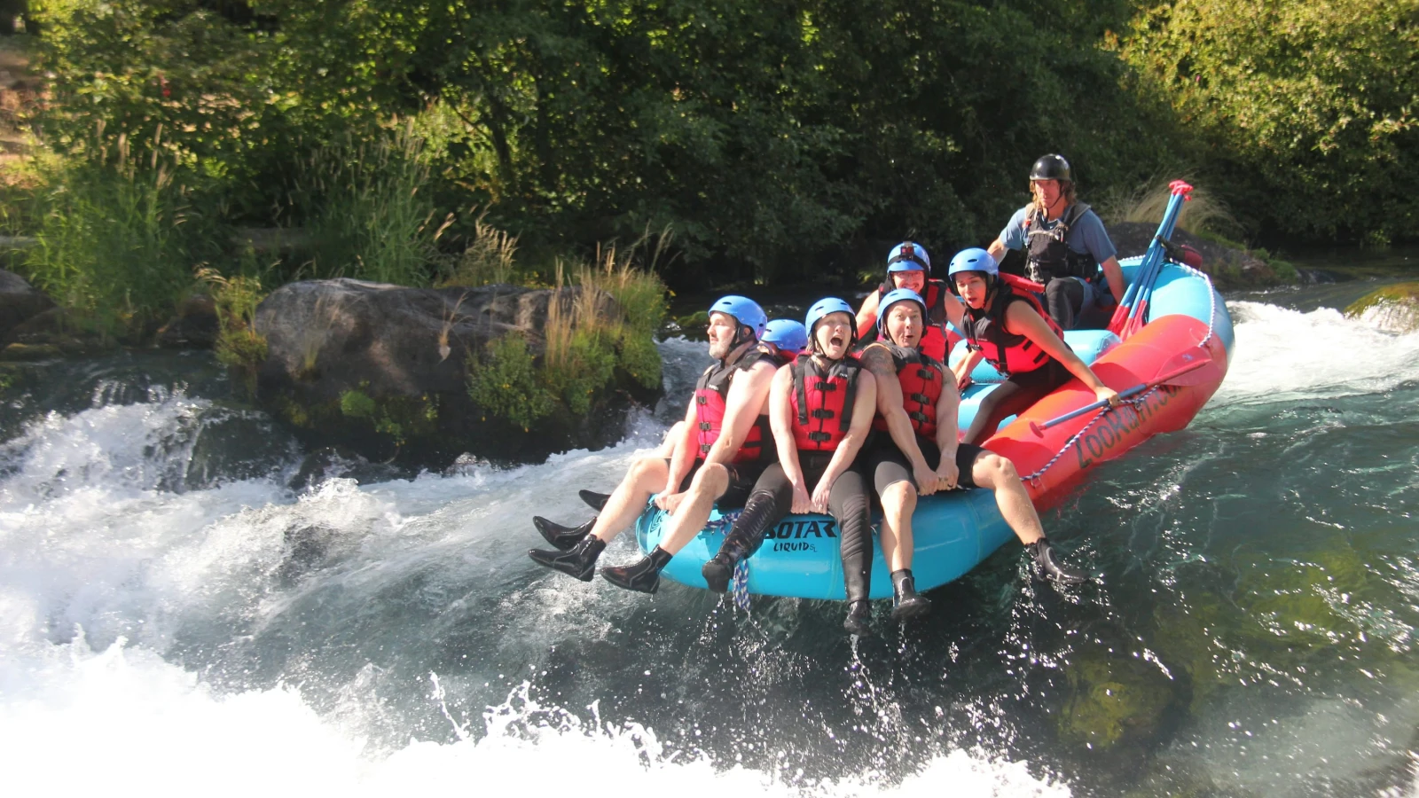 Grupo en una balsa inflable bajando rápidos de un río de montaña