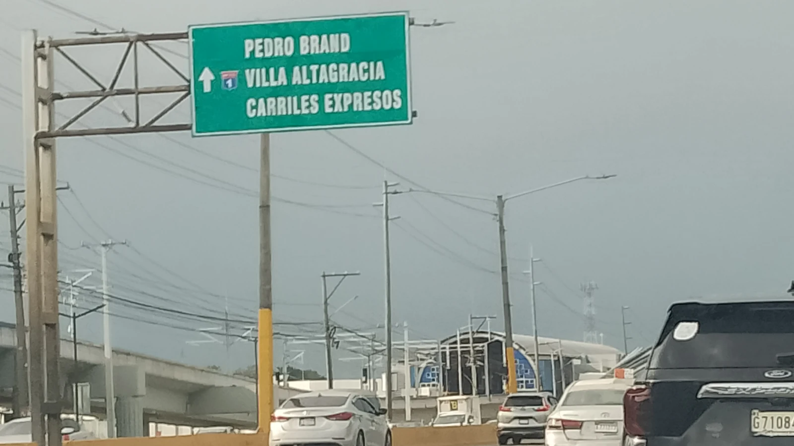 Tránsito en el kilómetro 15 de la Autopista Duarte, Santo Domingo, con letrero hacia Pedro Brand y Villa Altagracia